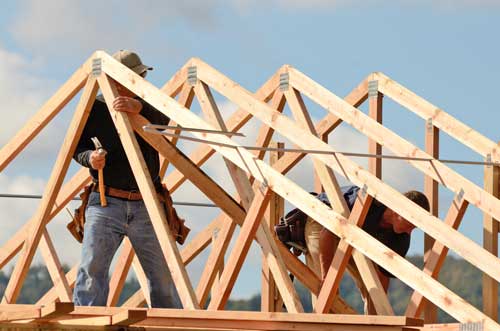 Charpentier effectuant des travaux sur une charpente en bois d'une maison