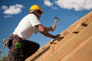 couvreur charpentier entreprise couverture entrain de travailler sur la charpente d'un toit